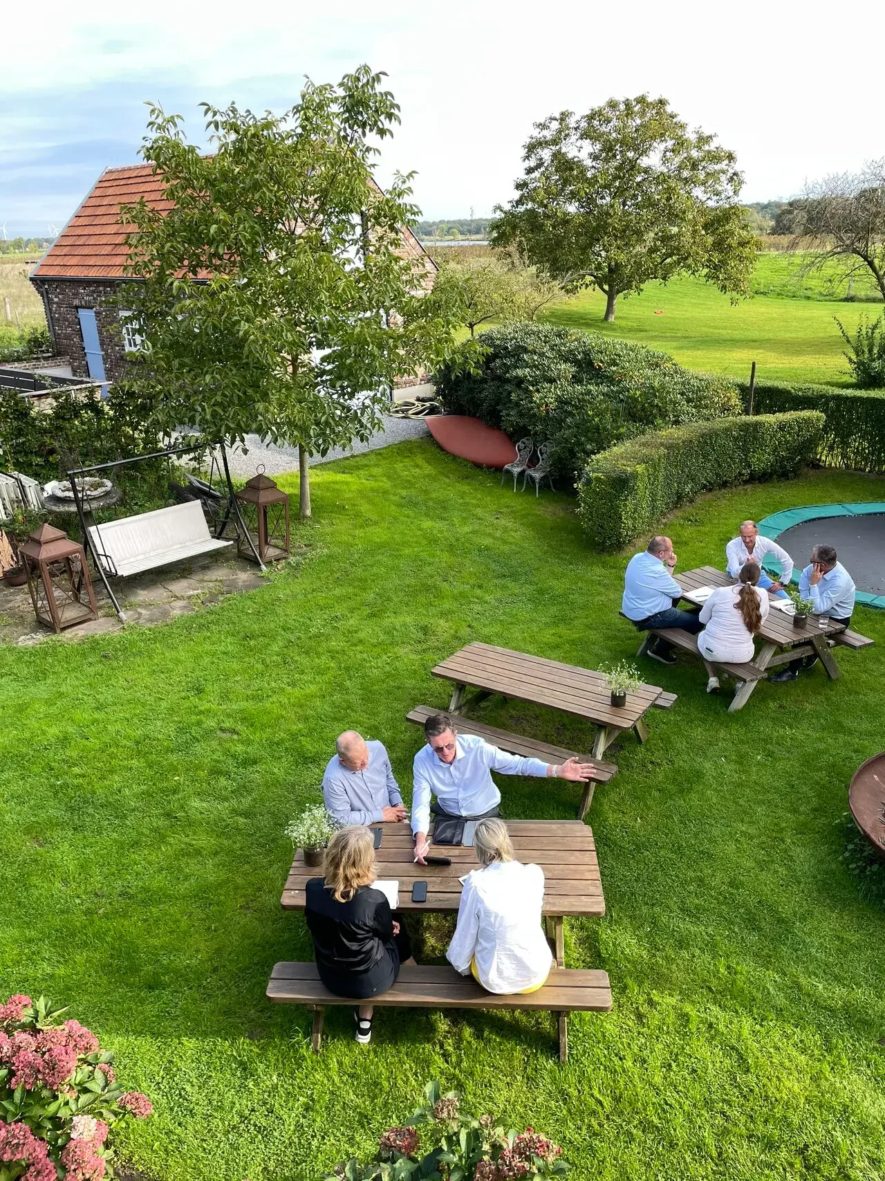 vergaderinng in de buitenlucht aan picknicktafels